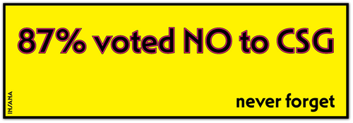 A bright yellow rectangular sign or poster with a black border, featuring the text '87% voted NO to CSG' in large dark red letters with a black outline, and 'never forget' in black at the bottom right. Small vertical text along the left edge reads 'INSANA'.